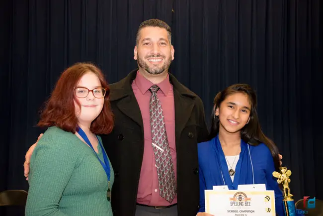 Buddy Taylor Middle School Principal John Fanelli has reason to be proud, as the winner of the 2018 county spelling be, 8th grader Keelin Cowart-Goldberg, left, and the runnerup, 7th grader Alisha Jageswar, are both his students. (Flagler Schools)
