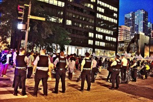 Police and protesters this week in Chicago, in reverberations of the police killing of 17-year-old Michael Brown in Ferguson, Mo. Click on the image for larger view. (Mikasi)