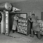 Before the establishment of the archives, many records were poorly stored. Here archives workers push a cart of Veterans Administration records into a vacuum chamber for fumigation in June 1936. Historic Photograph File of National Archives Events and Personnel, 1935 - 1975