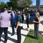 His glasses fogged up by condensation--he'd jus stepped out of an air-conditioned car into 90-degree heat--U.S. Rep. was greeted at the utility plant by Palm Coast Council member Theresa Pontieri, right, Council member Ty Miller, and Interim City Manager Lauren Johnston. (© FlaglerLive)