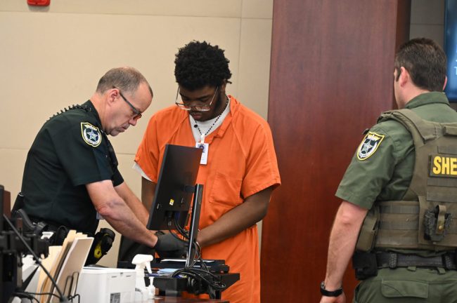 Brendan Depa getting finger-printed after his sentencing hearing on Aug. 6, 2024. (© FlaglerLive)