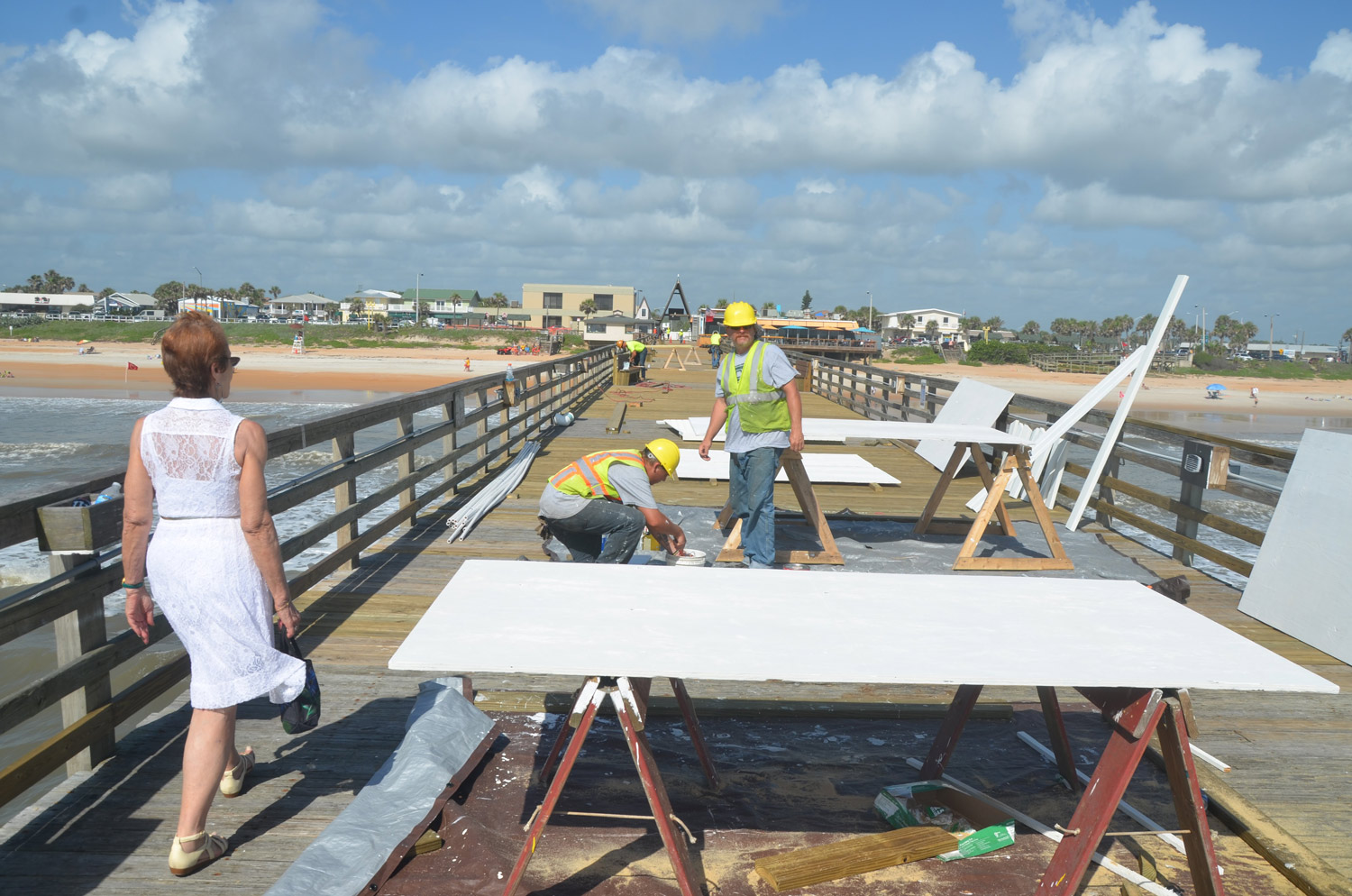 Flagler Beach City Commission Chair Jane Mealy walked to the edge of the the pier for the first time since Hurricane Matthew as workers put on the finishing touches. Standing in the middle was David Marine, one of the workers with the contractor, who happens to live a block and a half away from the pier. Click on the image for larger view. (© FlaglerLive)