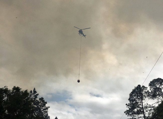 Flagler County Fire Flight, the emergency helicopter, was dumping water on the b;laze all afternoon. (Forest Service) 