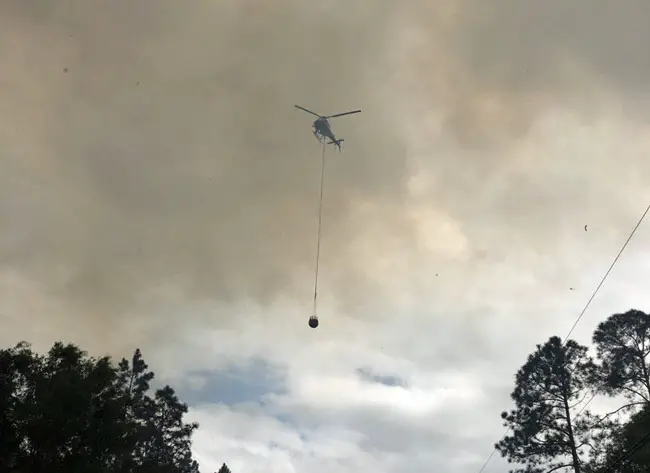 Flagler County Fire Flight, the emergency helicopter, was dumping water on the b;laze all afternoon. (Forest Service)