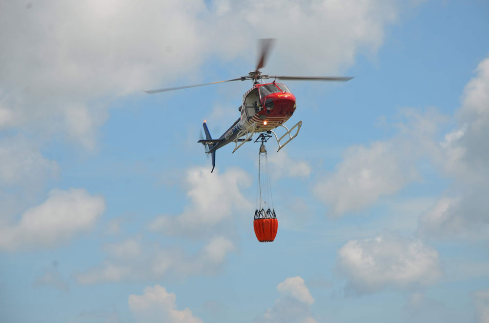 Flagler County Fire Flight, the emergency helicopter, and its water bucket. Emergency personnel hope to use the helicopter as little as possible as the fire season ramps up, with a burn ban intended to minimize emergencies. (© FlaglerLive)