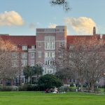 Students sit on blankets on Florida State University’s Landis Green on Dec. 31, 2024, with Landis Hall in the background. (Photo by Jay Waagmeester/Florida Phoenix)