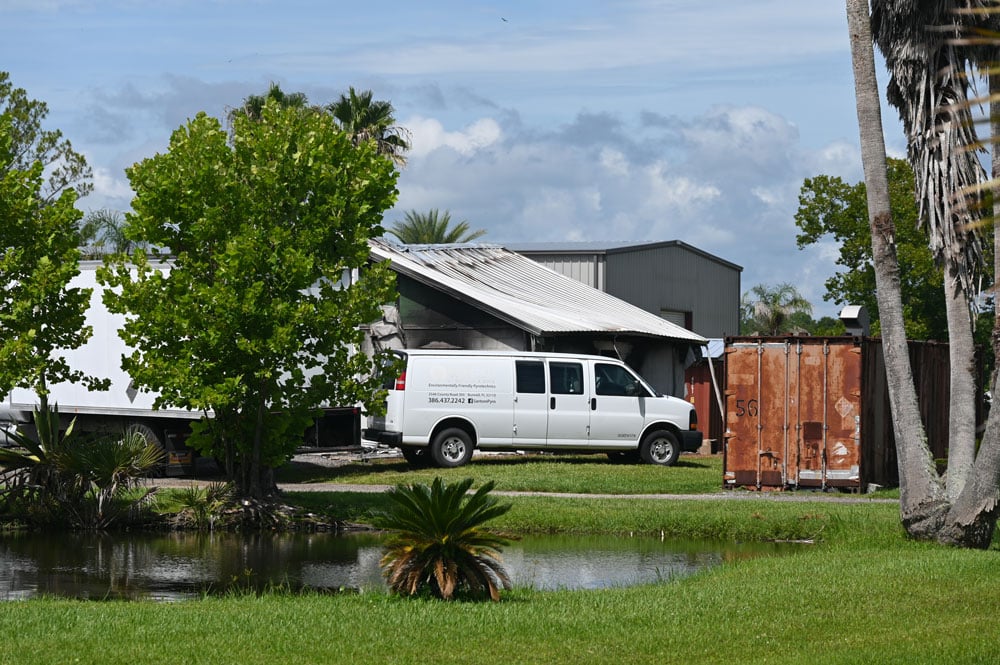 The company had positioned vehicles against the burnt building to block its view at Santore and Sons in West Flagler. (© FlaglerLive)