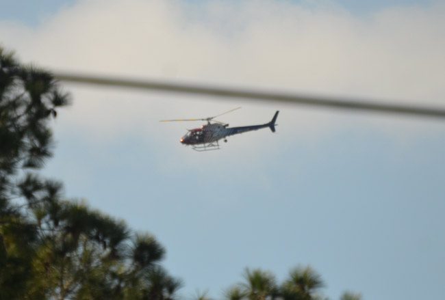 Flagler County Fire Flight, the county's emergency helicopter, circling a neighborhood of the P-Section this morning. (© FlaglerLive)