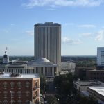 The Florida Capitol building, left, and the Florida Department of Education's white high-rise against the Tallahassee skyline. Neither institution is regulating the private schools tax dollars are underwriting. (© FlaglerLive)
