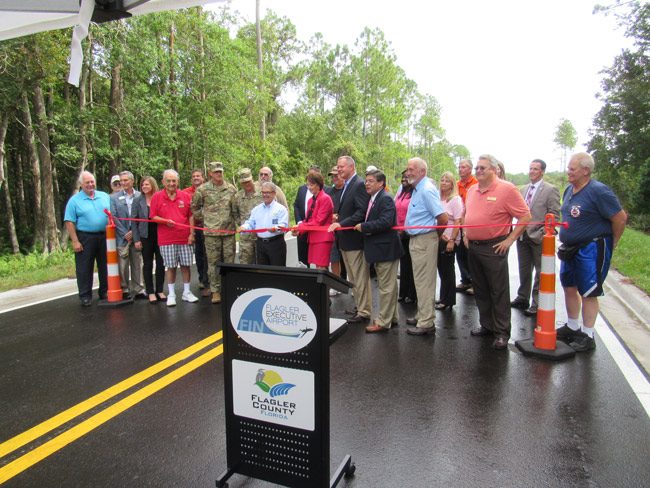 The Flagler County Airport, renamed Flagler Executive Airport, finally gets its road at the sough end, making possible the groundbreaking of the future National Guard building. The county's Mosquito Control District's new building is also under construction by the road. Flagler County commissioners held a ribbon-cutting Monday morning. (© FlaglerLive)