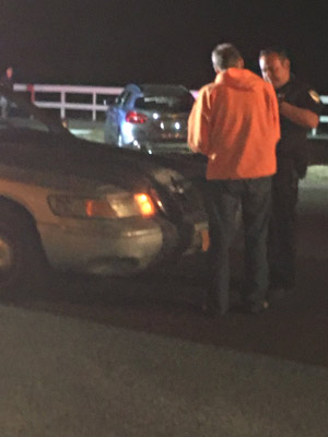 A law enforcement officer with the driver, who was released from the scene at about 7:50 p.m. (© FlaglerLive)
