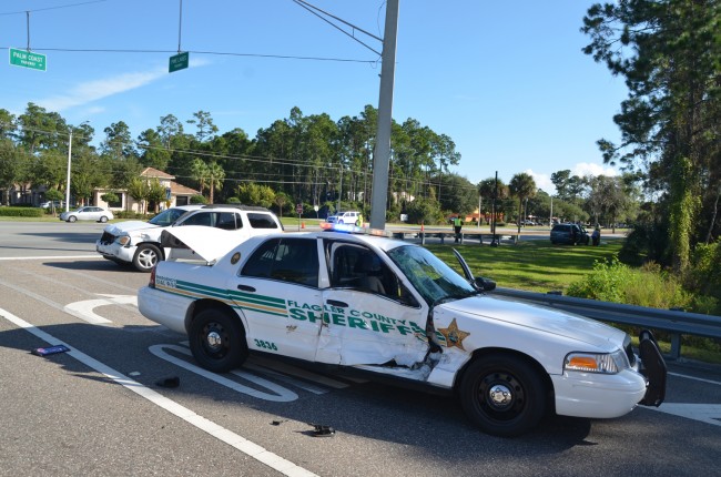 Flagler County Sjheriff's deputy James Gore was struck on the passenger side by the GMC SUV at Palm Coast Parkway and Pine Lakes Parkway Thursday morning. Click on the image for larger view. (© FlaglerLive)