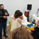 Vincent Cona, for whom Vincent's Clubhouse is named, embracing his mother and Vincent's Founder Erica Flores, with her husband, Hector Flores, left, at Tuesday's ribbon-cutting. (© FlaglerLive)