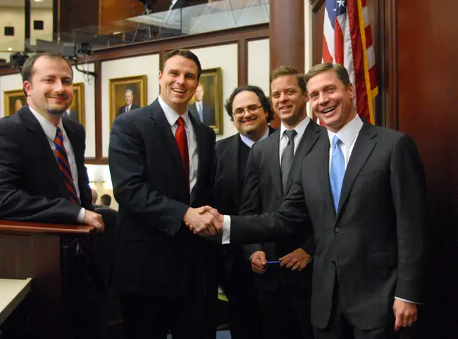 Time to cash in: With staff and Majority Leader Carlos Lopez-Cantera, R-Miami, at their sides, Speaker Dean Cannon, R-Winter Park, right, and Speaker-designate Will Weatherford, R-Wesley Chapel, center, handshake as the 60-day 2012 session drew to a close last March. (Florida Legislature)