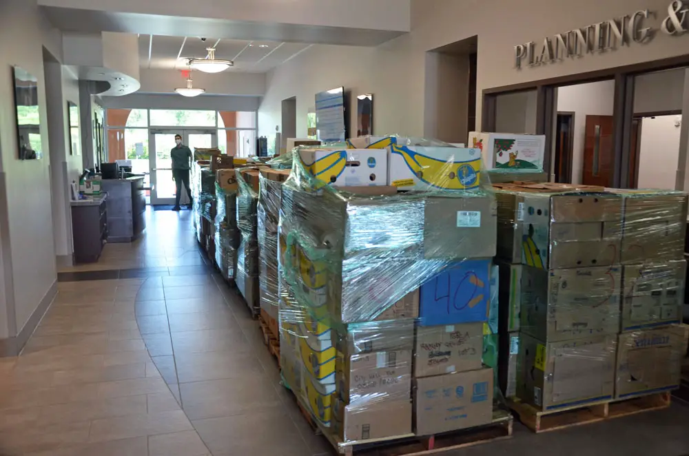 Some 1,200 booxes, each with a week's worth of groceries for a family of four, are warehoused on the first floor of City Hall, in preparation of the food drop on May 2. The city's Tyler Jarnagin is by the door. (© FlaglerLive)