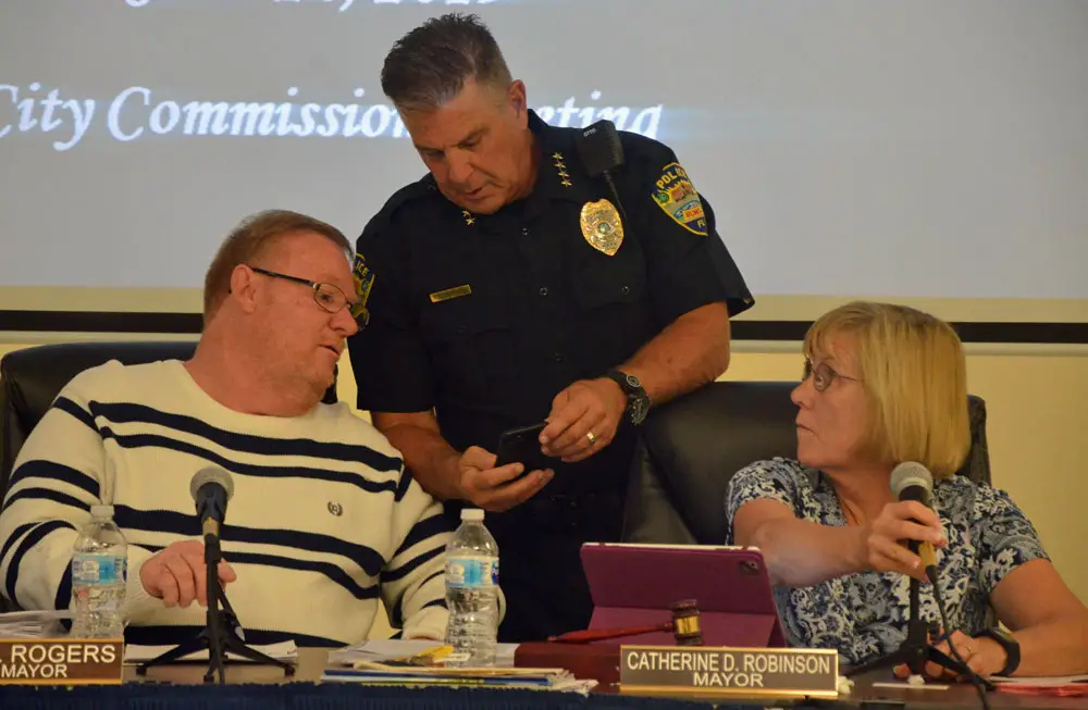 Bunnell Police Chief Tom Foster, who left the city last week, seen here at a previous City Commission meeting, with Commissioner John Rogers and Mayor Catherine Robinson. (© FlaglerLive)