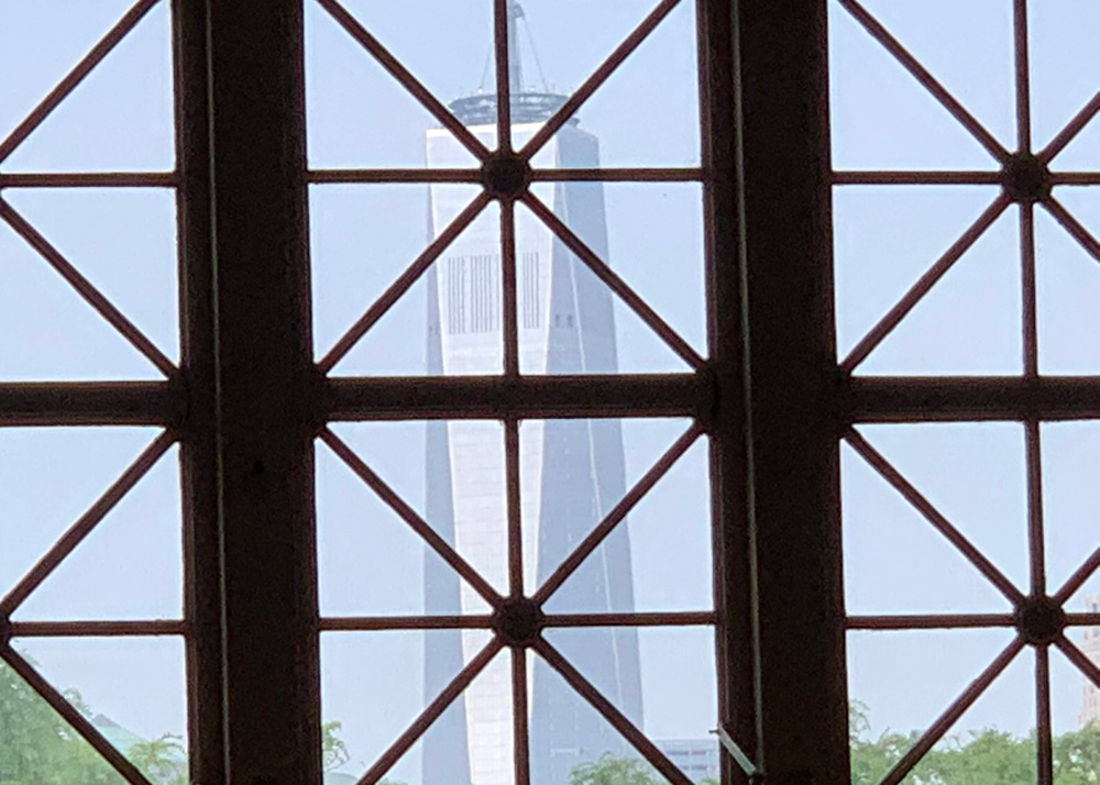 The Freedom Tower in Manhattan, seen through a window of the Great Hall on Ellis Island. (© Pierre Tristam)