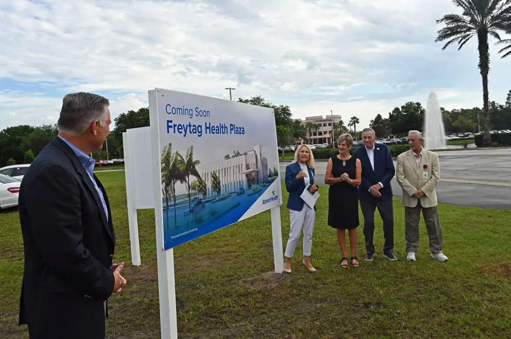 As AdventHealth Palm Coast Foundation Executive Director John Subers looked on, AdventHealth Palm Coast CEO Denyse Bales-Chubb this morning unveiled plans for a 30,000 square foot medical building on the front parcel of the hospital on State Road 100, named for Peter and Sue Freytag, (third and fourth from left), who marked the unveiling with Foundation Chairman Tony Papandrea. (© FlaglerLive)