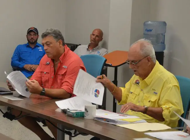Florence Fruehan, in the orange shirt, faces an accusation that he improperly touched a woman during a medical exam, when Fruehan was a physician. He has since been ordered to stop practiving medicine and has agreed to surrender his license. He also serves on the East Flagler Mosquito Control District board, an elected panel of three chaired by Julius Kwiatkowski, above in the yellow shirt. (© FlaglerLive)