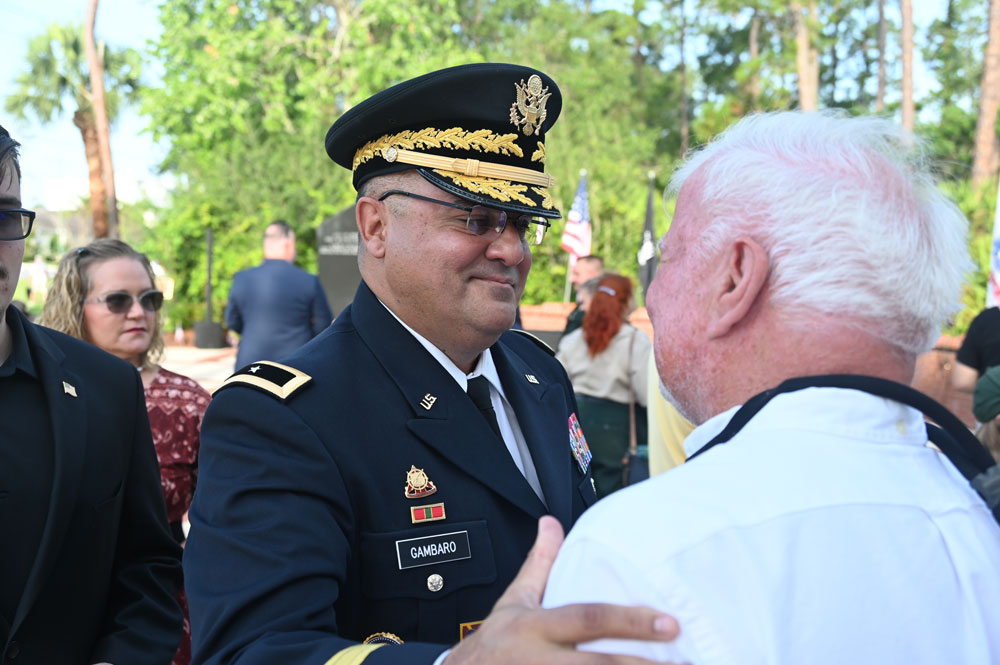 Charles Gambaro, a brigadier general in the Army Reserve, speaking with Ed Fuller at last May's Memorial Day ceremony in Palm Coast, an event U.S. Rep. Randy Fine attended. (© FlaglerLive)