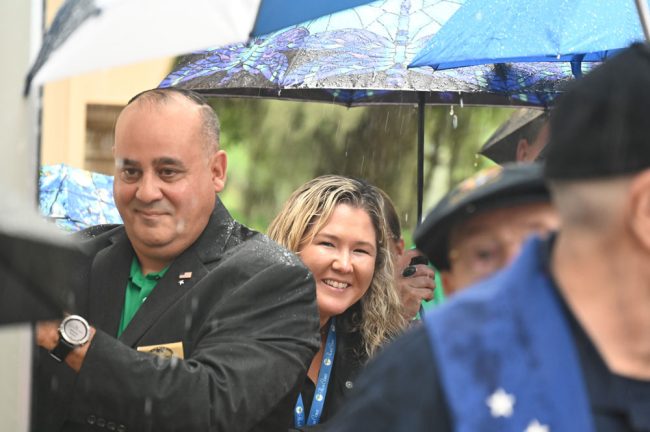 City Council member Charles Gambaro and City Manager Lauren Johnston in the rain during the blessing. (© FlaglerLive)