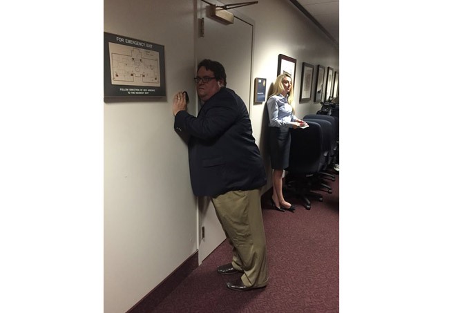 Gary Fineout, the Associated Press reporter, listens to a secret meeting of House members as they discussed the state's Medicaid issues Tuesday in an image tweeted by the AP's Curt Anderson. House members claimed the meeting was legal. 