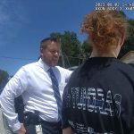 Flagler County Sheriff's detective Adam Gossett speaking with Brandon Gray Jr. after his arrest, outside his home in the Woodlands today. (© FlaglerLive via body cam video)