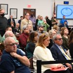 The Palm Coast City Council chamber was at capacity this morning as hundreds of residents and supporters of the Green Lion restaurant at Palm Harbor Golf Club turned up to protest the city council's severing of the lease after five years. Sitting in the first row, to the left of the masked woman, are Carolyn Marlow, Tony Marlow, and Linda Provencher, the former Flagler Beach mayor who worked for the Marlows for 20 years. They also own the Golden Lion restaurant in Flagler Beach. (© FlaglerLive)