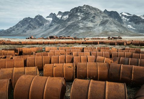 Rusting fuel drums and vehicles remain at an abandoned U.S. World War II base in Greenland.
