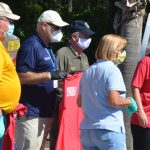 County Commissioner Greg Hansen in the yellow shirt with other local officials at last month's big food distribution in Palm Coast. (© FlaglerLive)