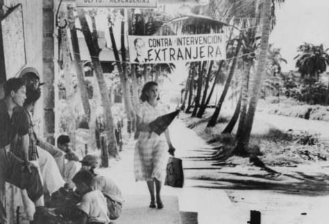 A woman walks past a banner that says ‘against foreign intervention,’ in Spanish, in Guatemala in 1954. Bettmann/Getty Images