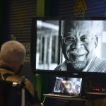 Jim Guines watching a retrospective of his life 10 years ago at a celebration of his legacy at Flagler Palm Coast High School. (© FlaglerLive)