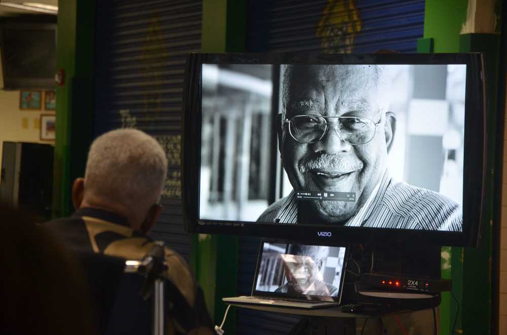Jim Guines watching a retrospective of his life 10 years ago at a celebration of his legacy at Flagler Palm Coast High School. (© FlaglerLive)