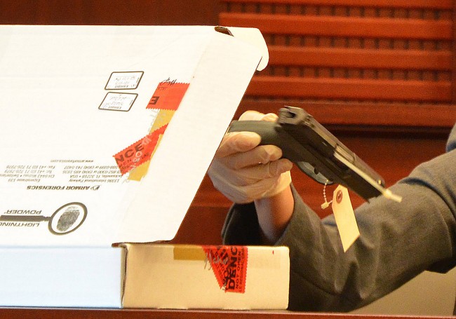 The 9mm gun Paul Miller used to murder his neighbor Dana Mulhall in Flagler Beach in March 2012, as Maria Pagan, an FDLE crime analyst, displayed it during the trial that led to Miller's conviction on a second-degree murder charge last month. Click on the image for larger view. (© FlaglerLive)