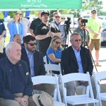 Sitting to the right, Mike Hahaj, Raydient's director of commercial development and operations, listened to Palm Coast Mayor Mike Norris lambast the westward expansion's Loop Road at its groundbreaking last May. The road is under construction. It is now going nowhere in a literal sense, as Raydient has pulled its plans. (© FlaglerLive)