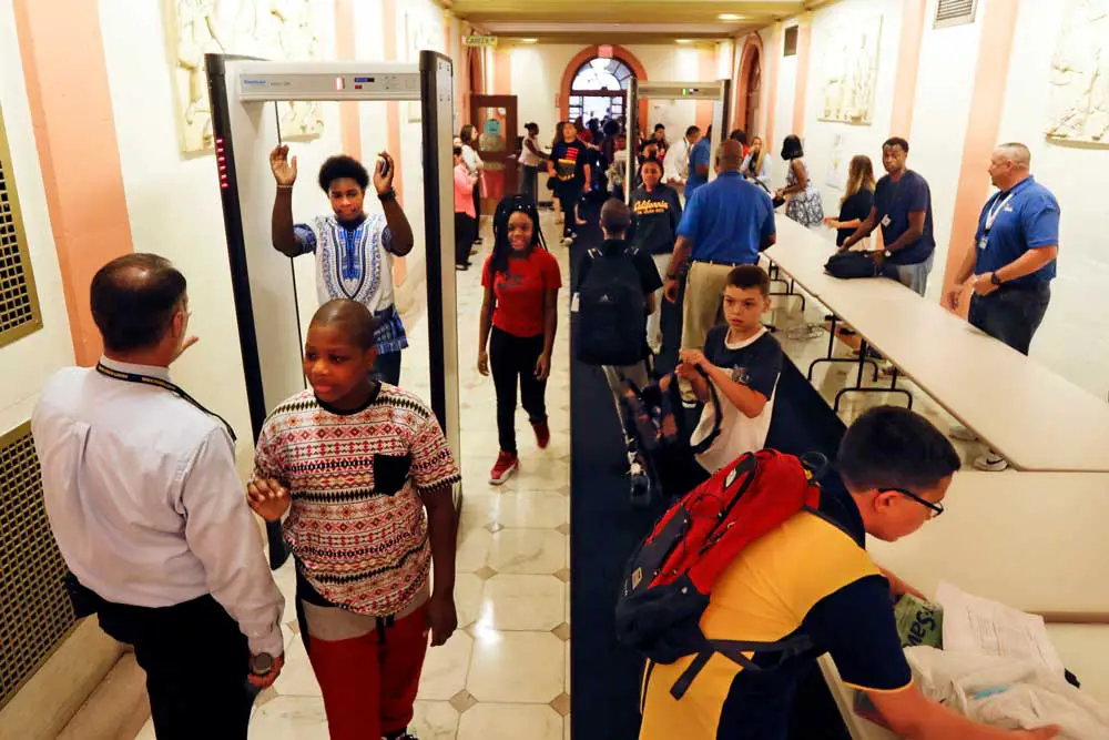 In this photo from 2016, students pass through a security checkpoint at William Hackett Middle School in Albany, N.Y., with guards, bag inspections and a metal detector. (AP Photo/Mike Groll)