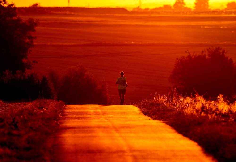 A runner tries to beat the heat by working out in the morning. (AP Photo/Michael Probst)