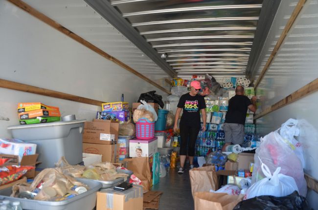 Heather and Scott Reinhardt organizing the 26-foot truck's contents around 9 a.m. today. (c FlaglerLive)