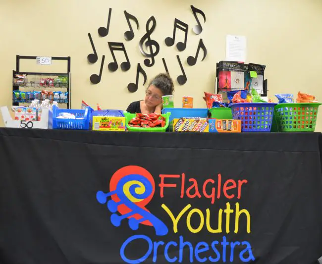 Helene Cangialosi, parent of two students enrolled in the Flagler Youth Orchestra, at the end of the day behind the Suite Shop, concessions that help defray the cost of the program, which enrolled some 400 students as it kicked off Monday. (c FlaglerLive)