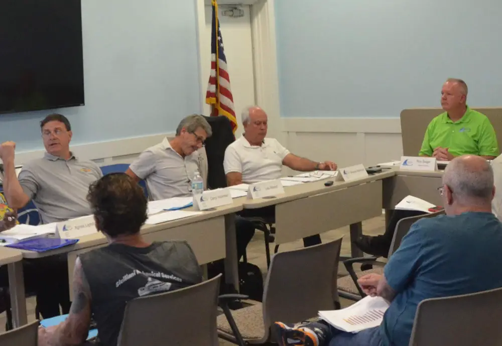 Daryl Hickman, left, at the last airport advisory board meeting he chaired, last week, with airport Director Roy Sieger in the green shirt. (© FlaglerLive)