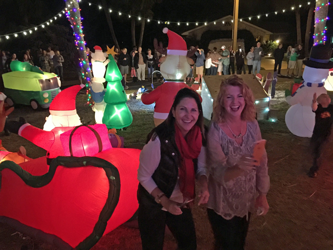 Two of the year's biggest local election winners, Palm Coast Mayor Milissa Holland, left, and School Board member and most-senior elected-official Colleen Conklin, celebrate the lighting of the Christmas display at Conklin's Flagler Beach house, an annual event that drew almost as many people as there were lights. The display is mostly the labor of Chris Conklin, Collen's husband, who estimates it takes about 60 hours to put together. (© FlaglerLive)