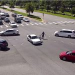 Christopher Holmes, his car stopped in the middle of the intersection, walked around gesturing. It was one amid a series of bizarre and criminal incidents Thursday afternoon. (© FlaglerLive via FCSO video)