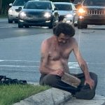 A homeless man on State Road 100 and Old Kings Road in Palm Coast. (© Pierre Tristam/FlaglerLive)