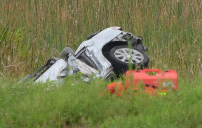 The Honda Civic crashed through the guardrail and rolled into a ditch between the southbound and northbound lanes of I-95. (© FlaglerLive)