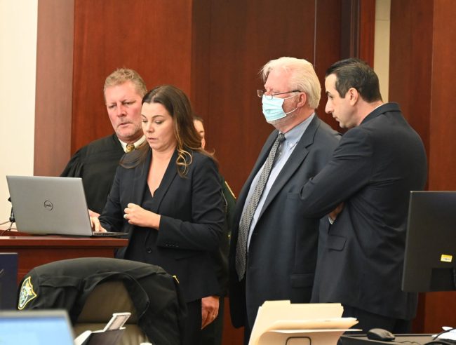 The huddle. From left: Circuit Judge Chris France, Assistant State Attorney Jennifer Dunton, court-appointed defense attorney Garry Wood, and Assistant State Attorney Jason Lewis. (© FlaglerLive)