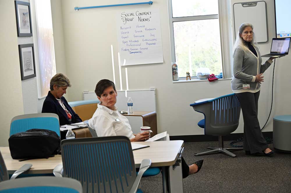 Sally Hunt, center, had not developed a rapport with Superintendent Cathy Mittlestadt, left, and was leaning toward not renewing her contract. (© FlaglerLive)