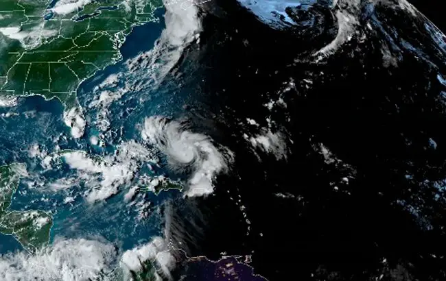 A satellite image of Hurricane Dorian approaching the Florida Peninsula as night falls behind it. 