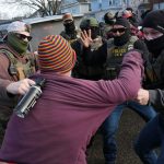 Protesters confront federal agents near the scene where Renee Good was fatally shot by an ICE officer in Minneapolis.