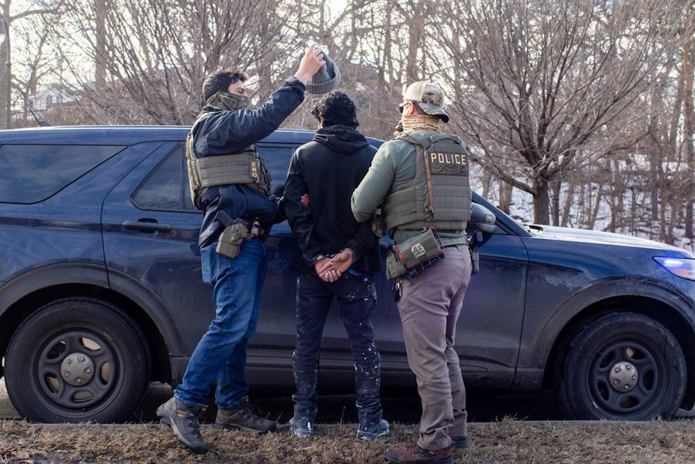 ICE agents search the passenger of a truck as they arrest both him and the driver during a traffic stop in February in Robbinsdale, Minn. Almost a quarter of ICE arrests in recent months have been “collateral,” a category that has raised legal questions, rather than “targeted” arrests based on preexisting warrants or removal orders. (Photo by Nicole Neri/Minnesota Reformer)