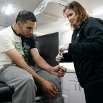A registered nurse treats Dominic Rodriguez for a skin injury related to xylazine use in Philadelphia in May 2023. Treatment vans are allowed in the city, but not supervised injection sites.